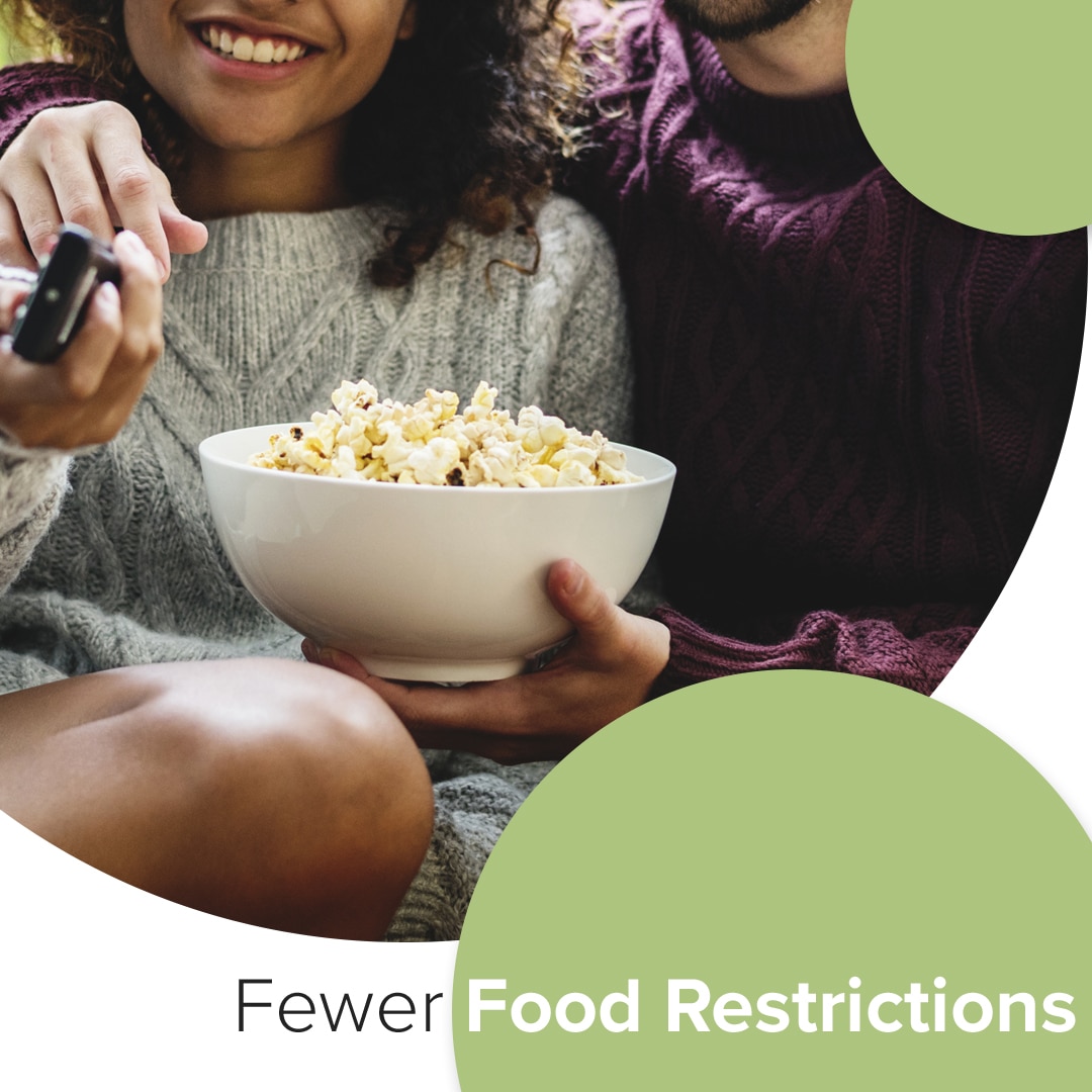 Two people enjoying popcorn together with text "Fewer Food Restrictions" promoting dental care benefits.