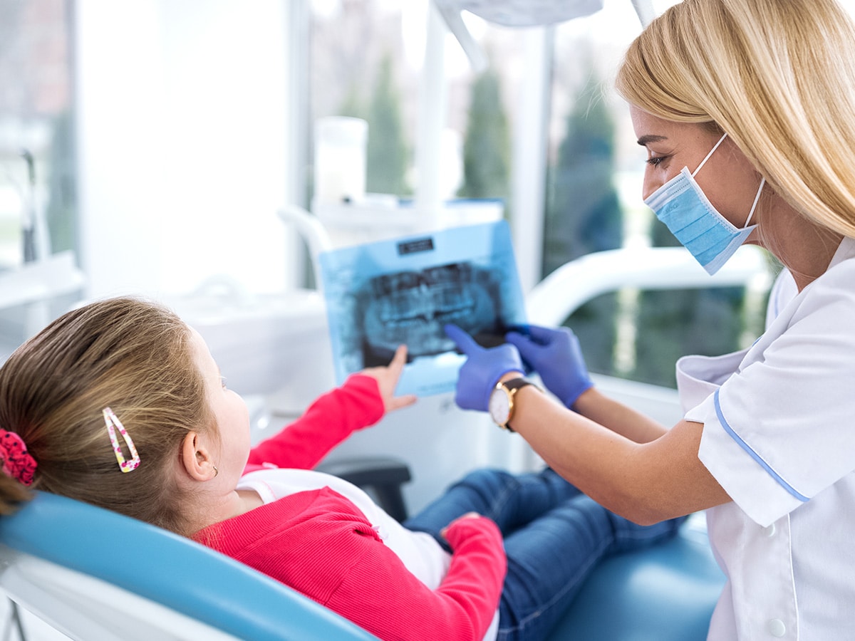 Image of a dentist showing a girl her x-ray