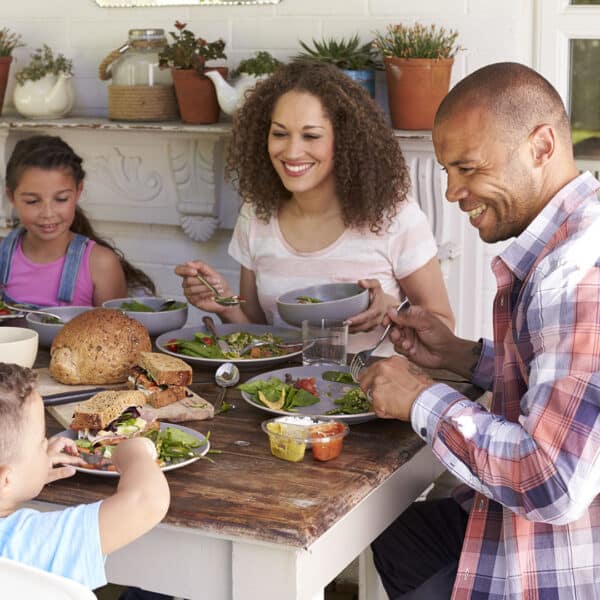 family smiling and eating dinner