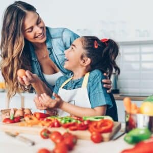 mom and daughter cutting up fresh vegetables