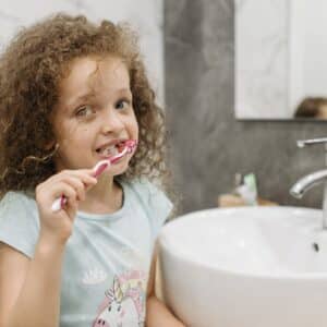 little girl brushing her teeth