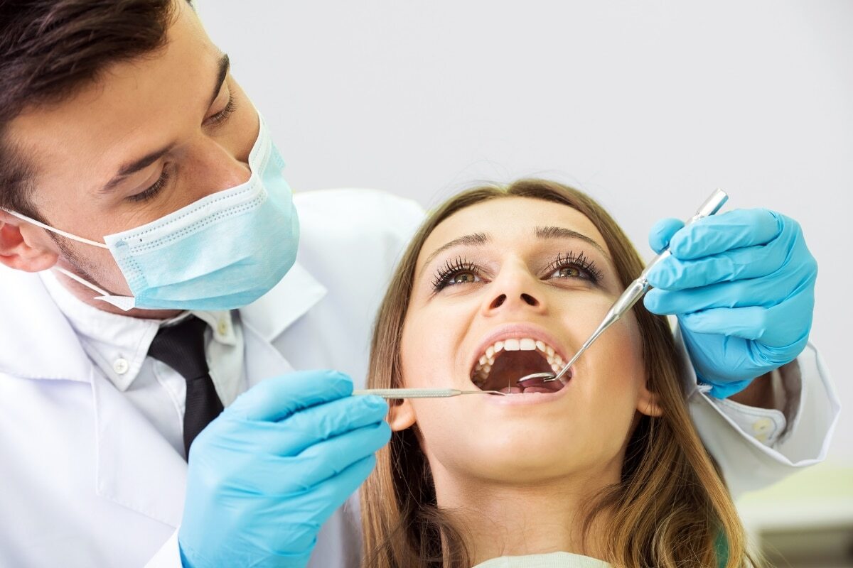 Dentist examining patient's teeth during dental exam at Denver, CO office.