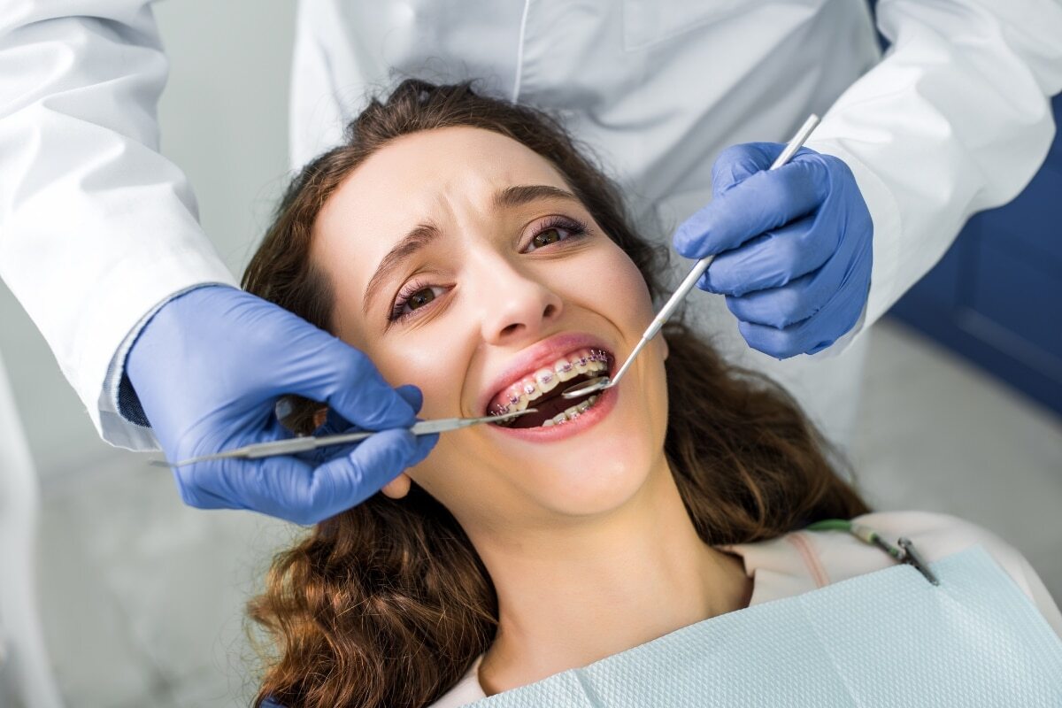 Patient receiving dental examination with braces at Denver dental office on W 44th Ave.