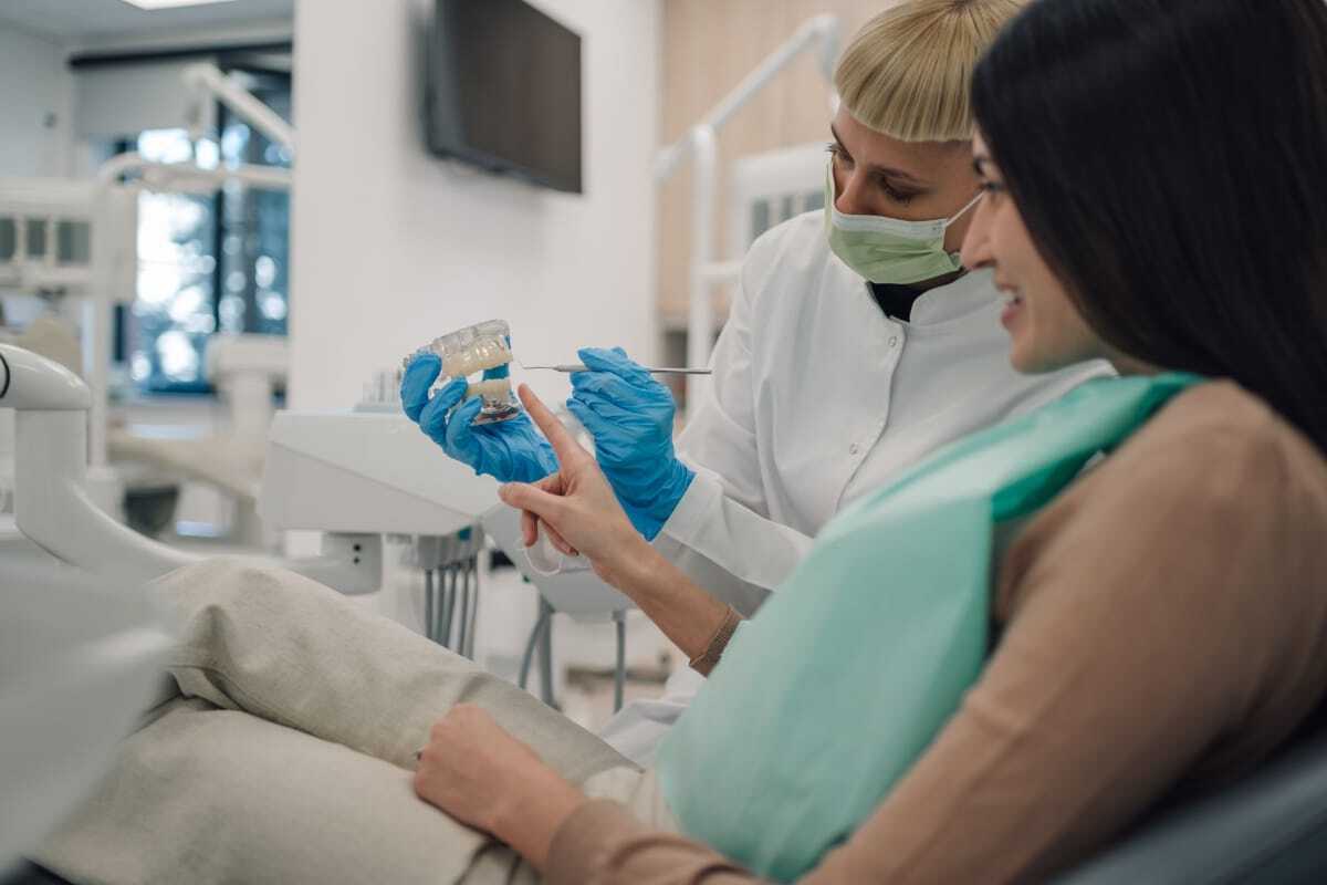 Dental hygienist showing dental material sample to patient at Denver family dentist office on W 44th Ave.